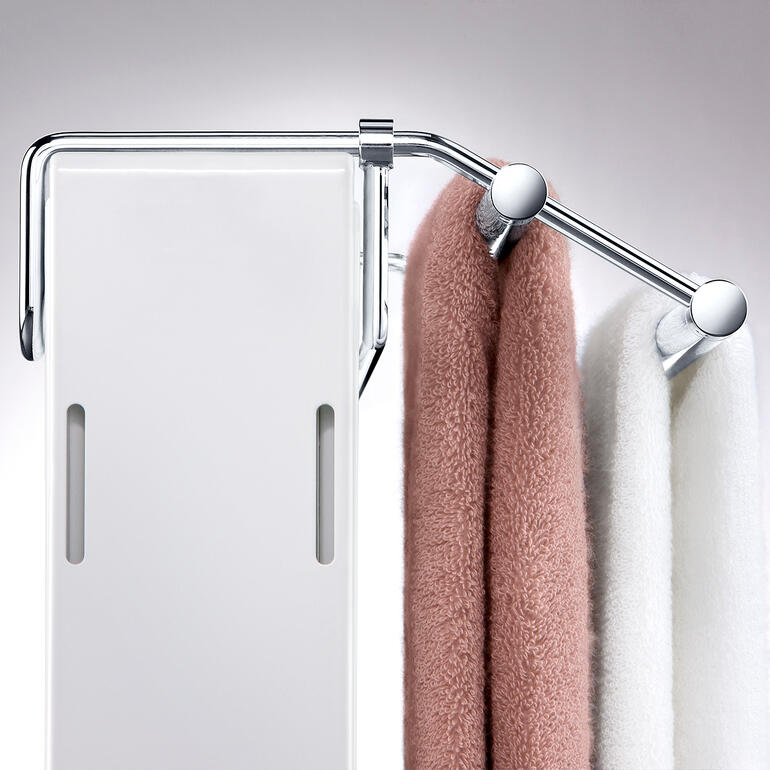 Per stufenlos verschiebbarem Bügel passen Sie den Halter exakt an die Heizkörpertiefe an. Detailansicht des Handtuchtrockners mit hängenden Handtüchern.