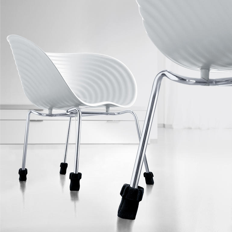 Schwarze Stuhlsocken 'Wukies' auf Möbelbeinen.