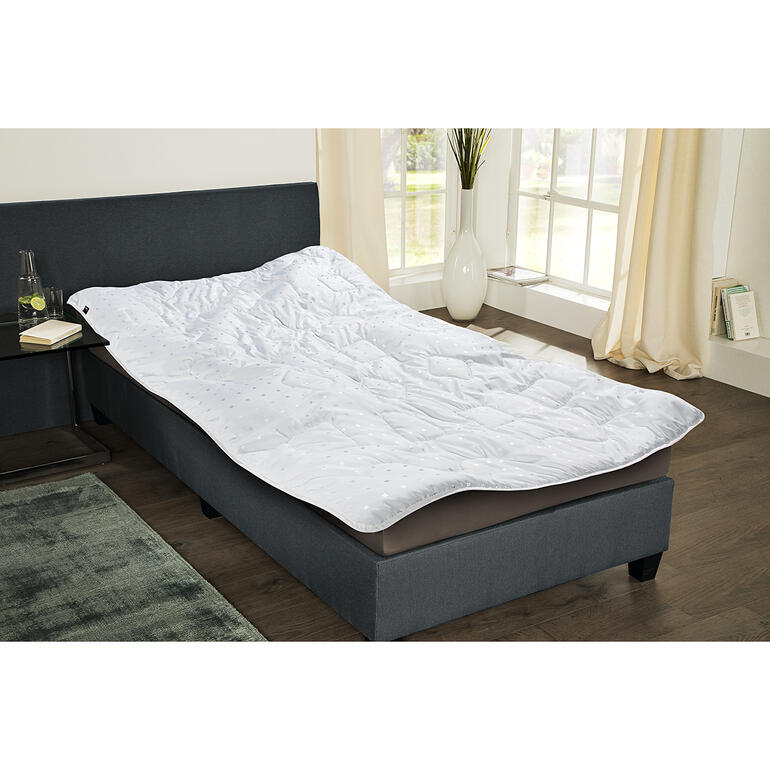 Leichtsteppbett auf einem Bettgestell in einem modernen Schlafzimmer