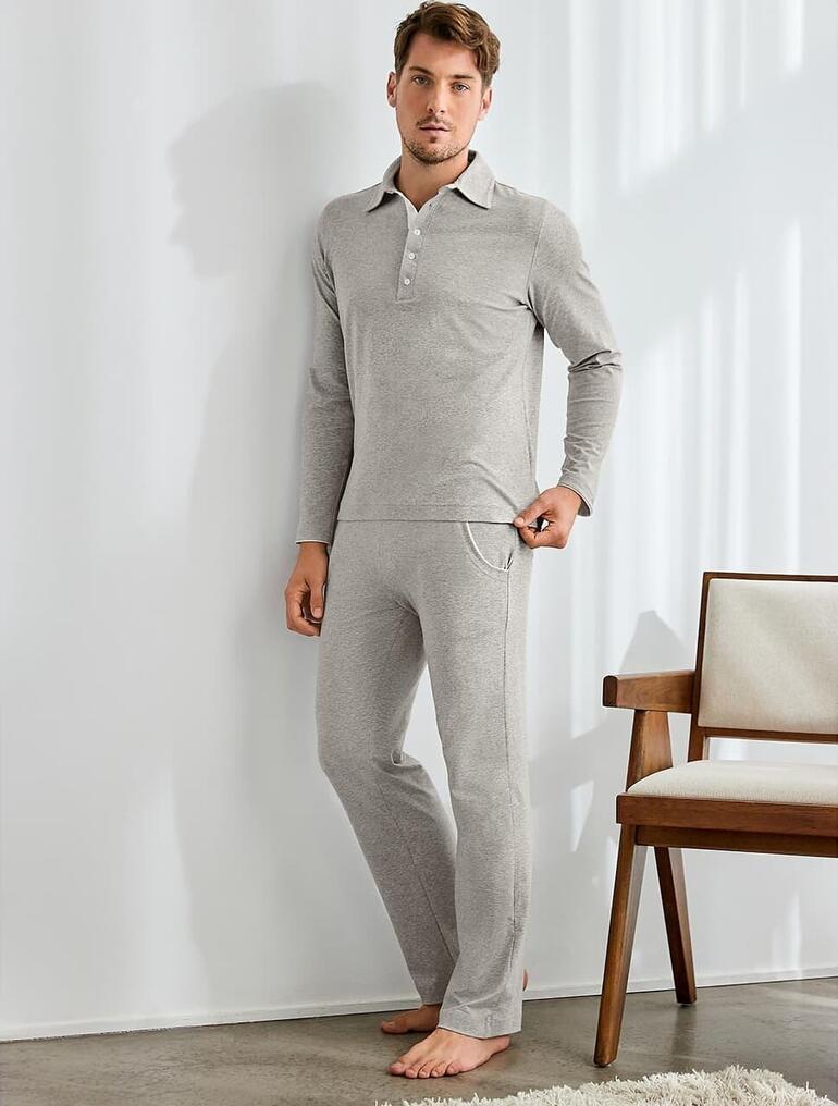 Mann in grau-meliertem Loungewear-Anzug steht im Raum