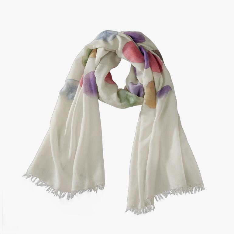 Farbiger Aquarell-Tupfen-Schal in Creme, Rot, Violett und Grün auf einem Tisch.