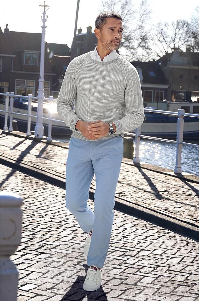 Mann trägt einen grauen Carbery Patentstrick-Pullover an einem Kanal.