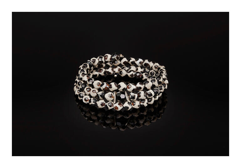 Langani Tibet-Achat-Armreif mit unterschiedlichen Perlenfarben auf schwarzem Hintergrund.