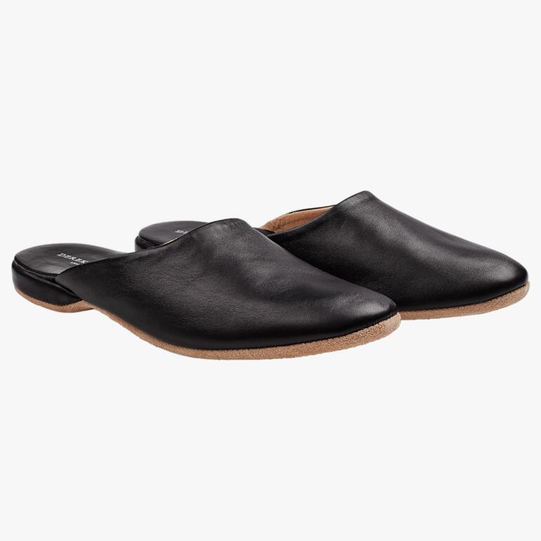 Schwarze Leder-Slipper mit einem weichen Obermaterial und flacher Sohle.