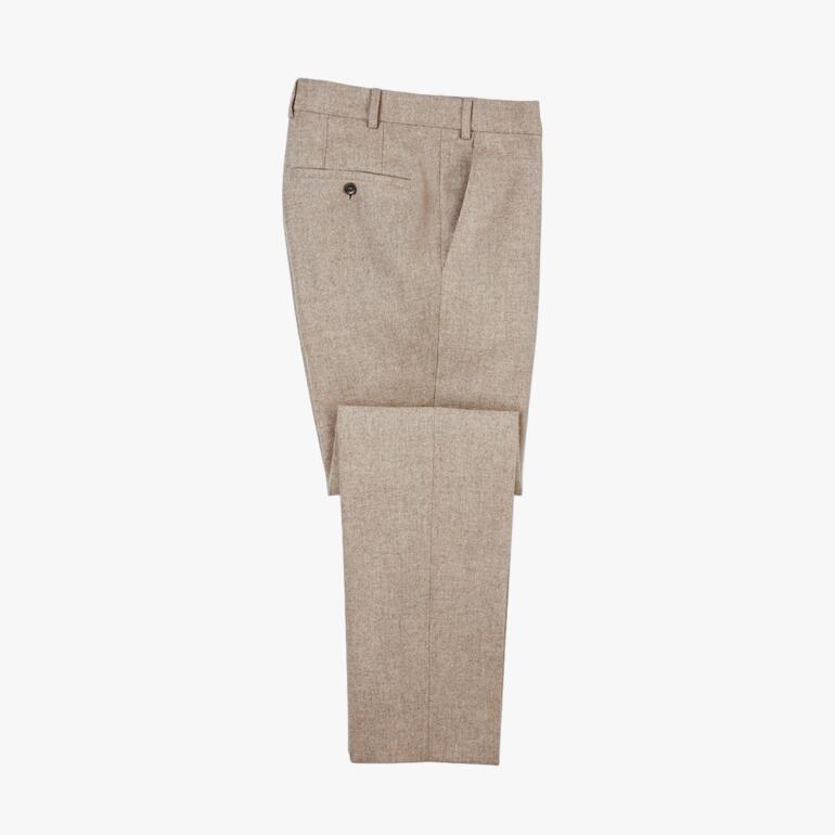 Helle, beige Stoffhose, auf einem weißen Hintergrund liegend.