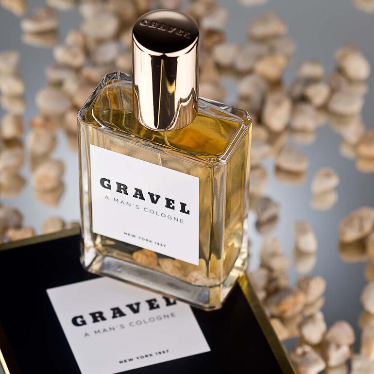 Gravel Eau de Parfum Spray, 100 ml, neben Steinen auf einem spiegelnden Tisch.