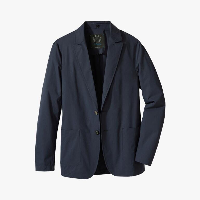 Revers des blauen Travel-Light-Jacket auf einem Tisch.