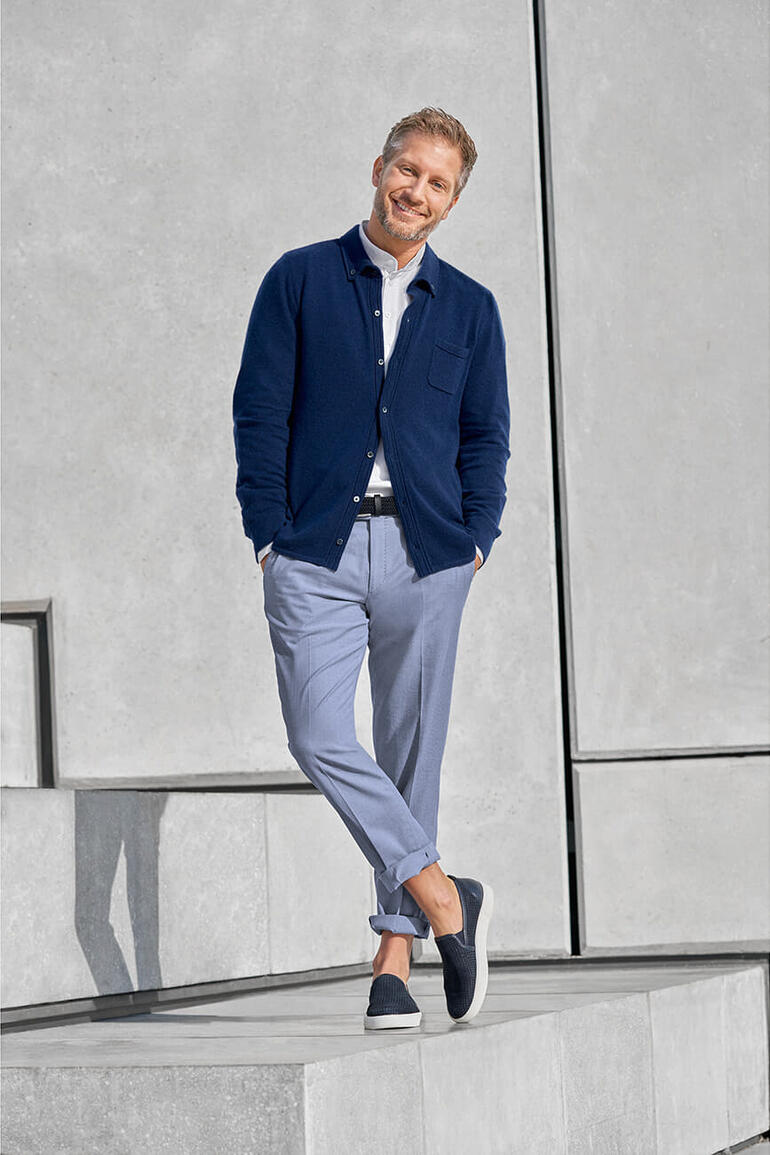 Mann in navy Feinstrick-Hemd mit Tasche steht auf Stufen