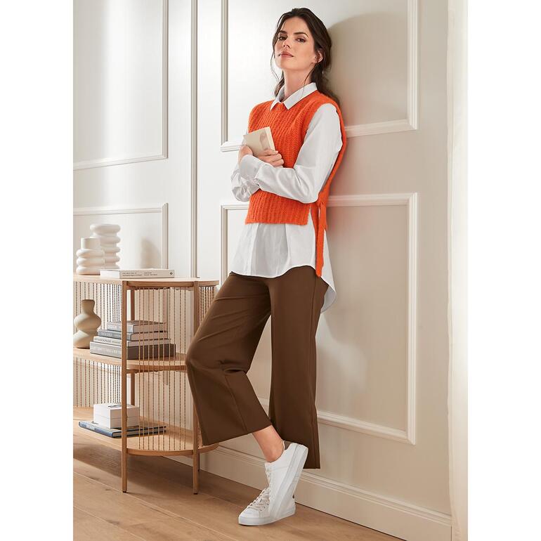 Punto Milano Wide-Leg-Pants, Braun Modische braune Weitbeinformhose mit weißen Sneakers, kombiniert mit einem orangefarbenen Pullunder.