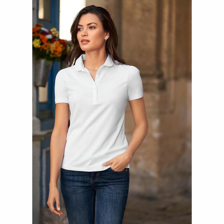 Weiß Frau trägt ein weißes Polo-Shirt, kombiniert mit dunklen Jeans, vor einer historischen Kulisse.