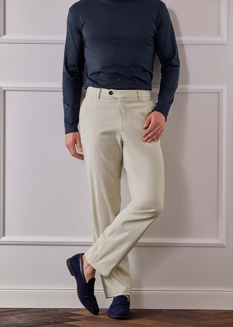 Mann in hellen Reisehosen steht auf einem kurzen Holzgeländer.