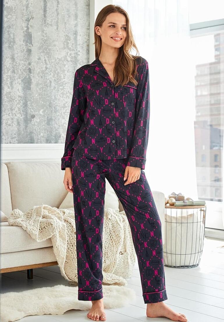 Frau in pink-gestreiftem Pyjama mit Logo von DKNY steht im Wohnzimmer.