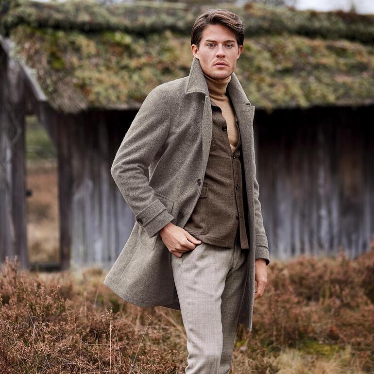 Carl Gross Easiness-Mantel in grauer Farbe, getragen von einem Modell im Freien.