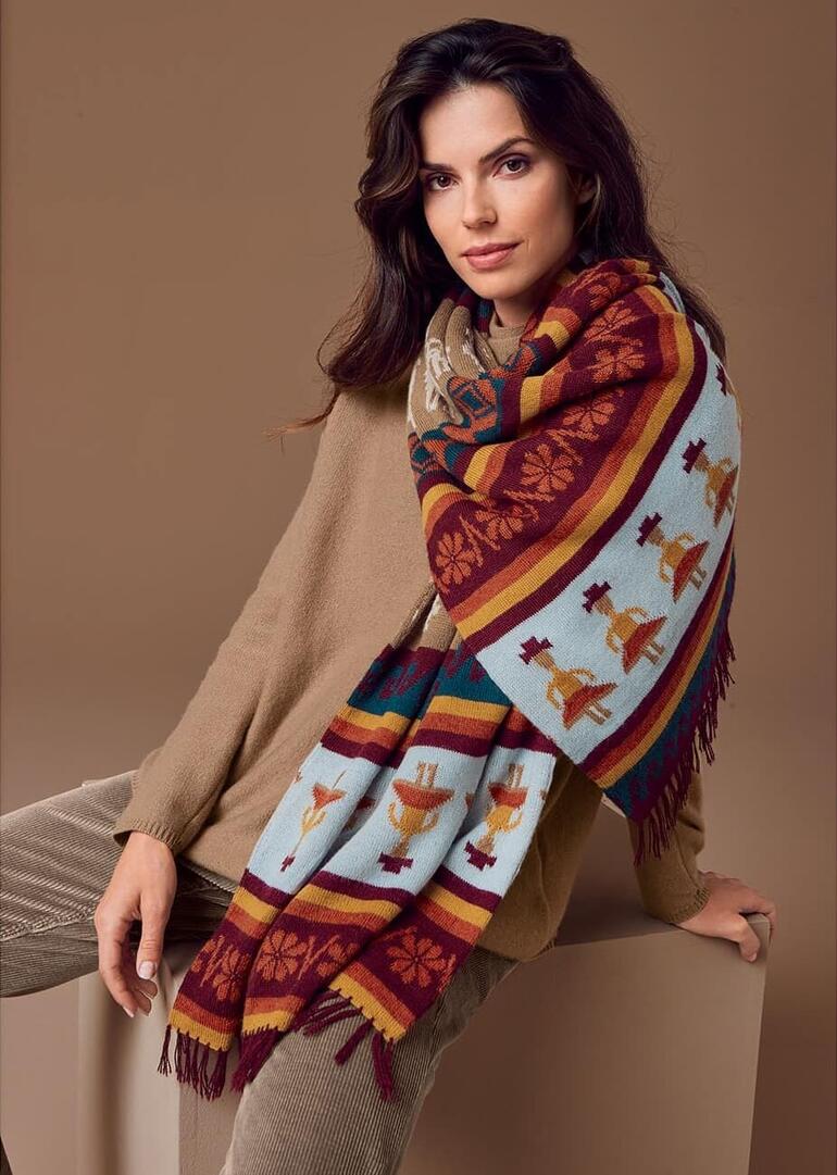 Frau mit handgestricktem Alpaka-Schal schaut in die Kamera.