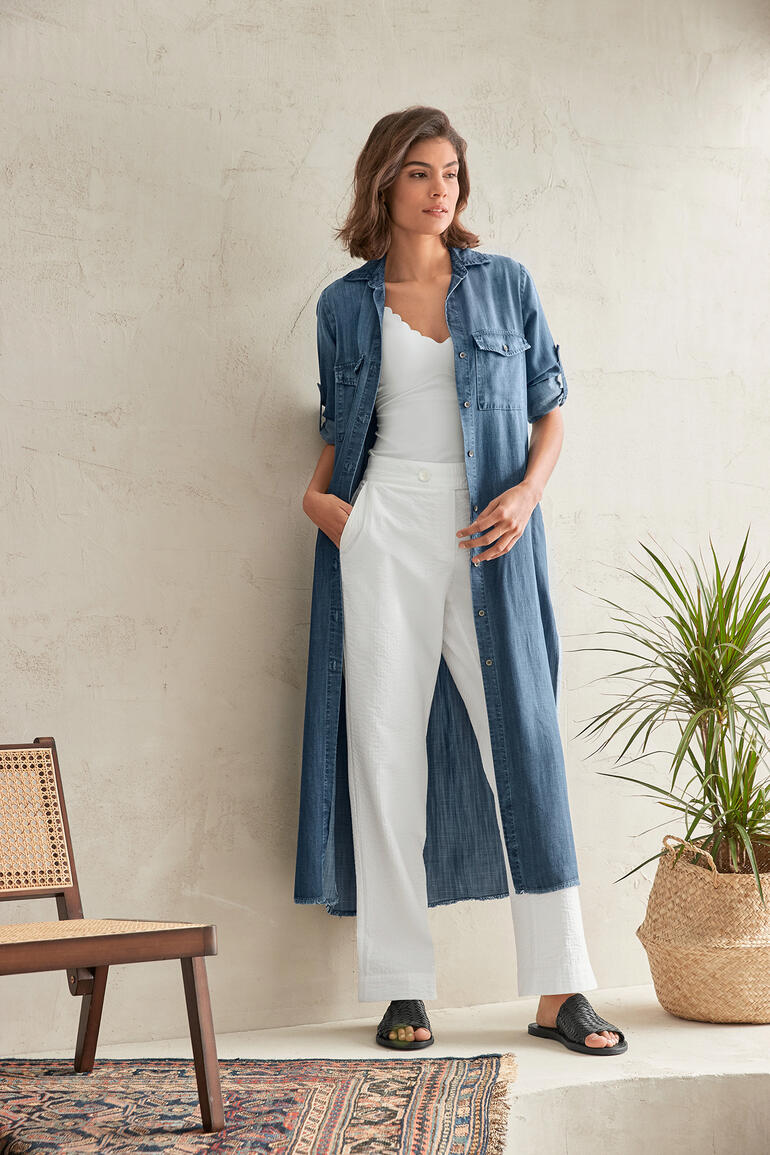 Bella Dahl Jeansblusen-Kleid Frau im Jeansblusen-Kleid steht an einer Wand mit Pflanze.
