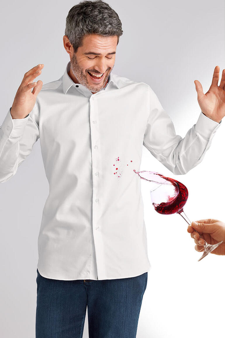 Mann in weißem Hemd, fröhlich mit Rotwein verschüttet.