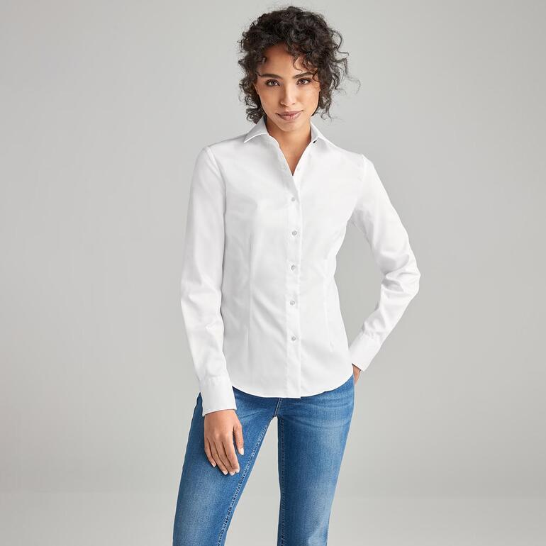 Weiß Frau trägt eine weiße QuickClean-Bluse mit aufgestellten Kragen und Knöpfen.