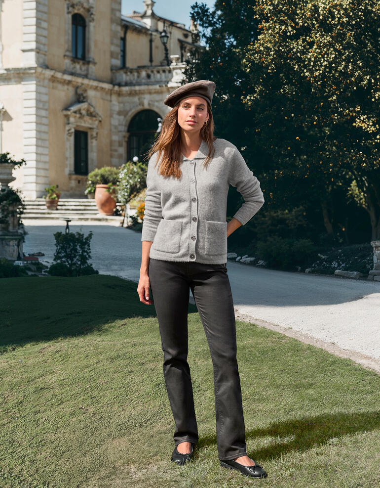 Frau trägt grauen Junghans Cardigan vor historischem Gebäude