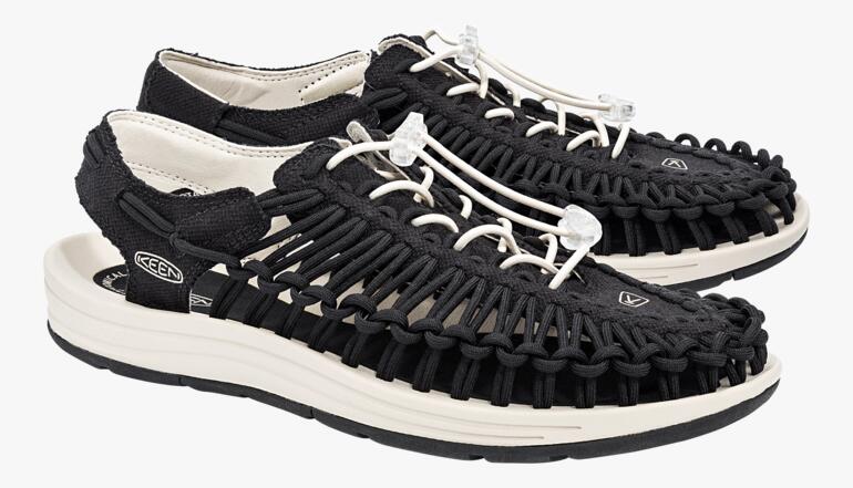 Paar KEEN Outdoor-Sandalen Uneek in Schwarz/Weiß auf weißem Hintergrund.