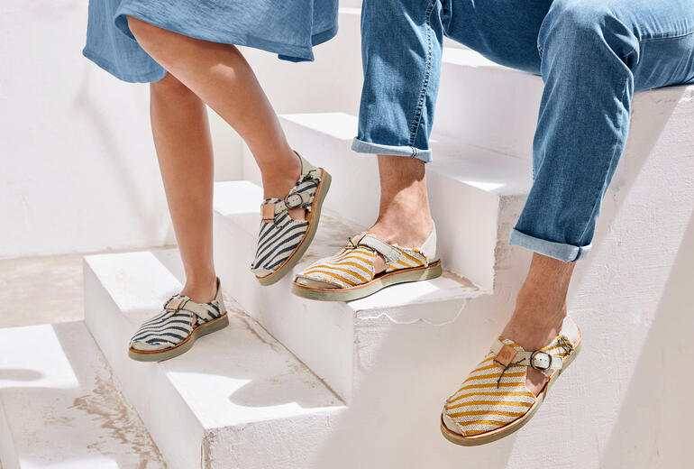 Zwei Füße in Satorisan Canvas-Sneaker-Sandalen auf einer Treppe