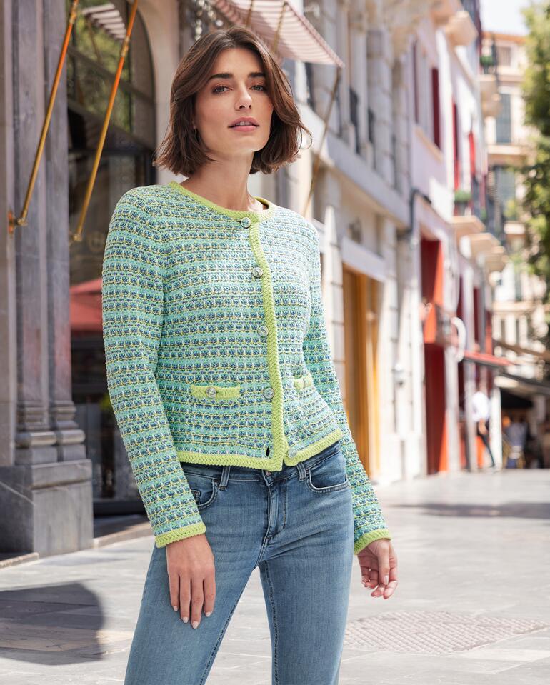 Frau posiert in der Junghans 1954 Couture-Strickjacke auf der Straße.