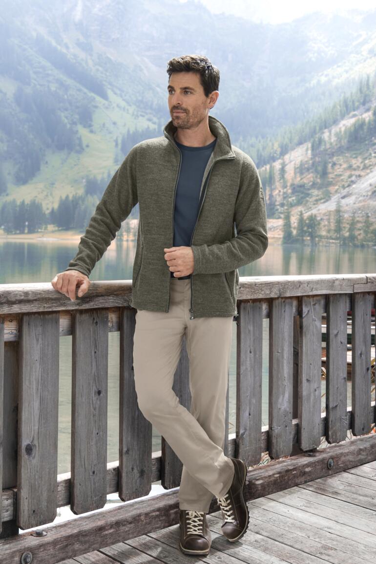 Mann in Tencel-Walkjacke steht am Ufer eines Sees.