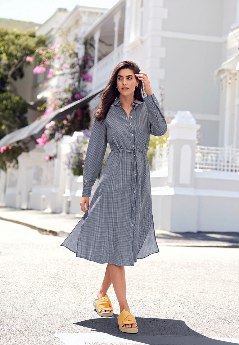 Gelb Damen in gestreiftem Seersucker-Kleid mit Gürtel, steht auf Straße