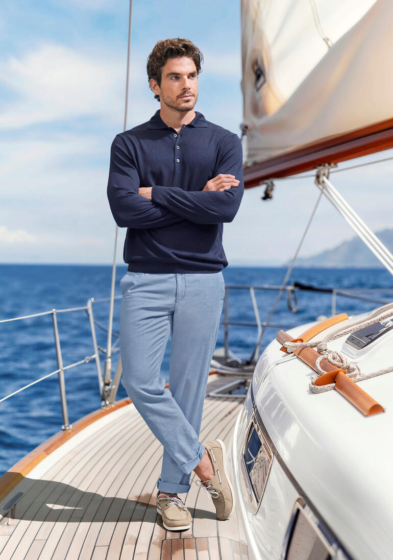 Mann in einem Bootsoutfit auf einem Boot mit maritimem Hintergrund.