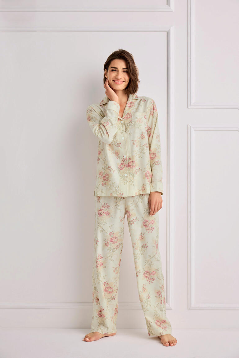 Frau in floralem Ralph Lauren Pyjama steht in einem hellen Raum.