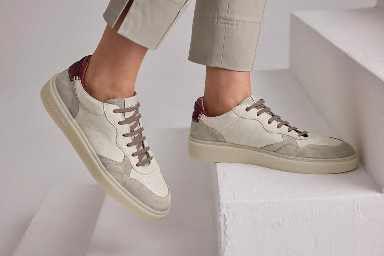 Beige Ducanero® Basic-Edel-Sneaker, getragen von einer Frau mit grauen Hosen.