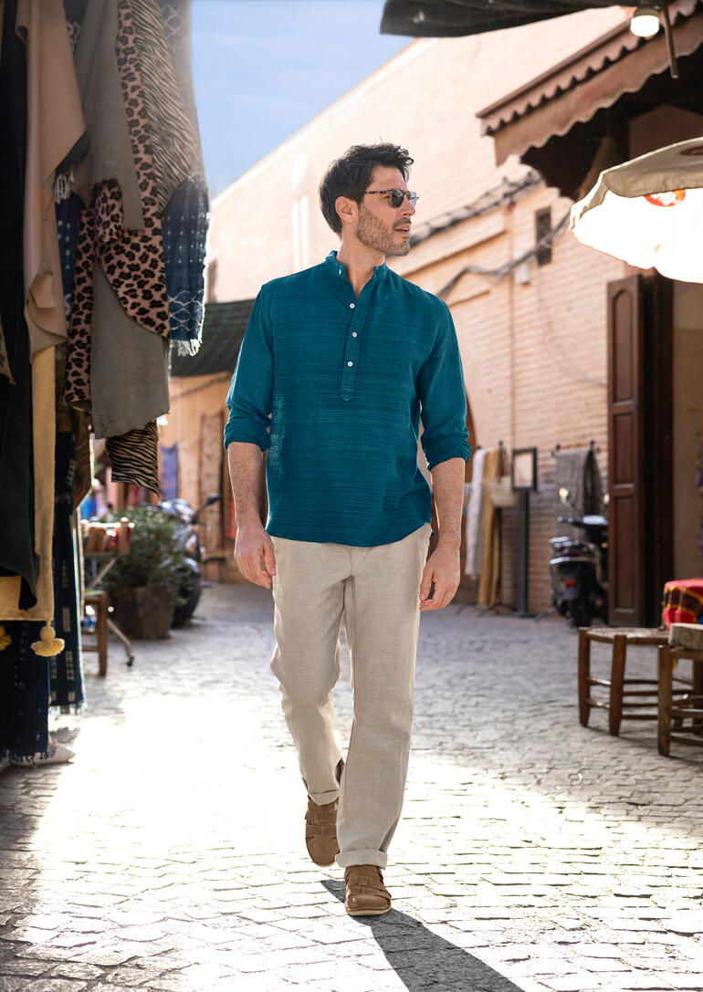 OMTC Handgewebte Seiden-Kurta Mann trägt handgewebte Seiden-Kurta in belebtem Markt mit Ständen.