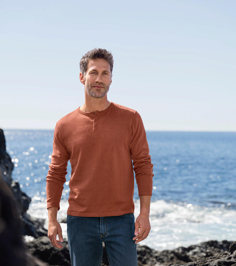 Ragman Casual Pullover Ein Mann steht am Strand in einem rostroten Ragman Pullover und Jeans.