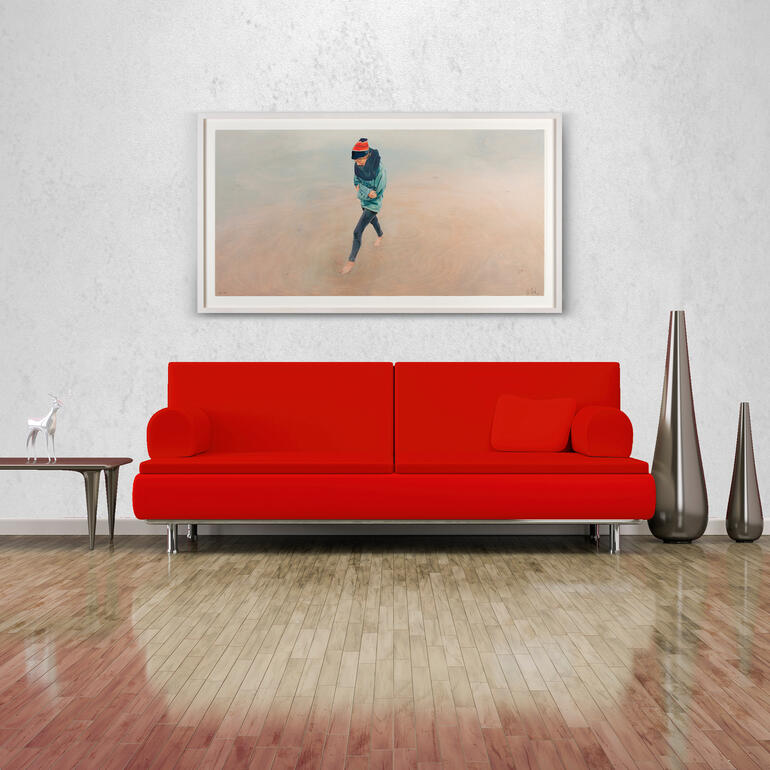 Rotes Sofa mit Bild einer Frau am Meer an der Wand