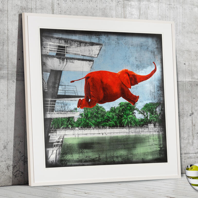 Ein roter Elefant springt von einem Gebäude über einen Pool