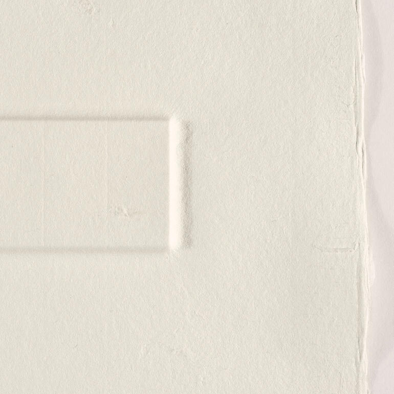 Detailaufnahme einer strukturierten, hellen Fläche ohne Farbe