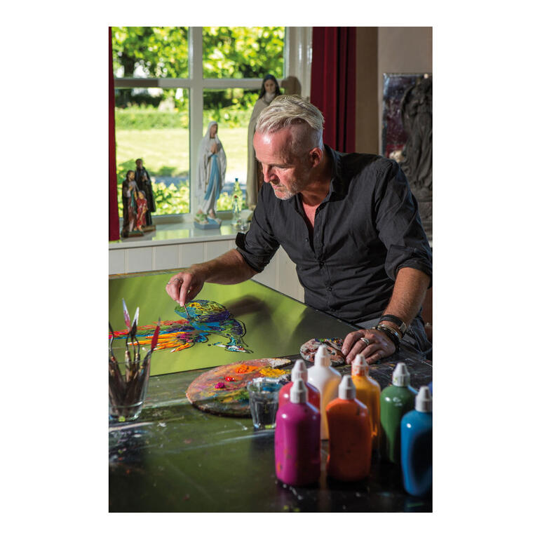 Paul La Poutré Paul La Poutré beim Malen, umgeben von farbigen Farben und einer hellen Fensteransicht.