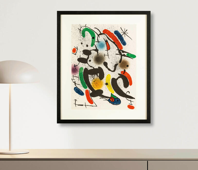 Kunstwerk von Joan Miró an einer Wand mit Tischlampe.