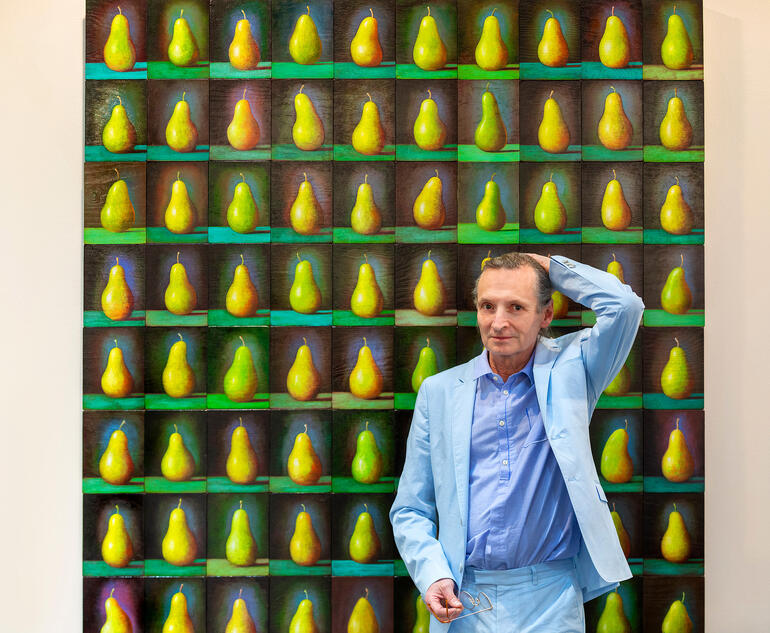 Andreas Scholz Mann posiert vor einer Wand mit gleichmäßigen Birnenarrangements.