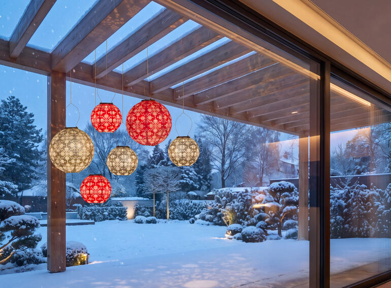 Fünf wetterfeste Lampions in Rot und Grau im Garten bei Schnee.