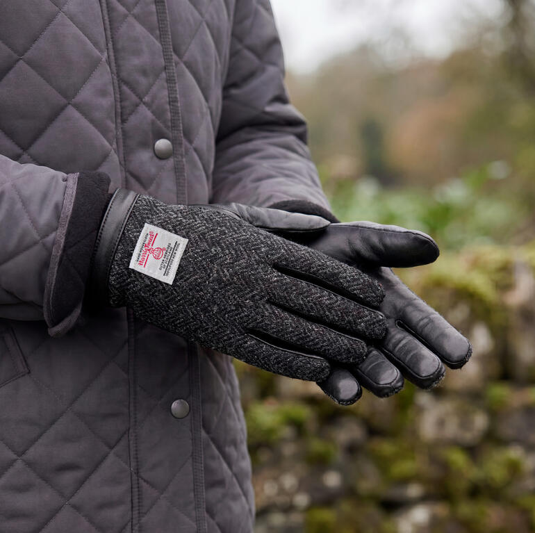 Schwarze Harris Tweed Handschuhe sind in einer nahen Ansicht zu sehen.