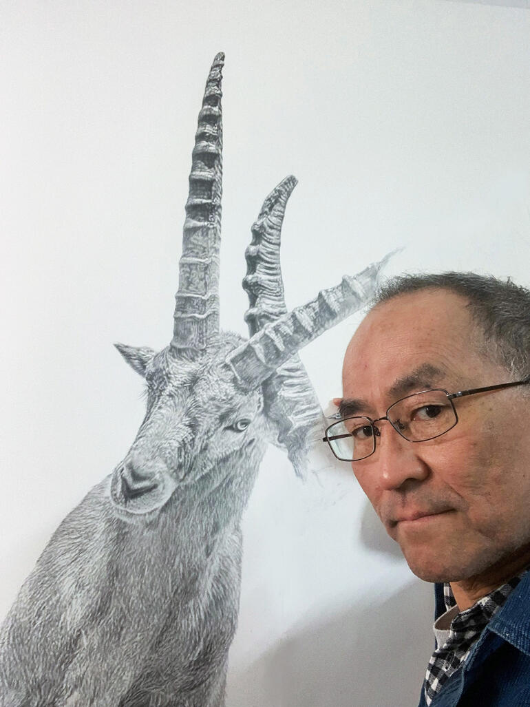 Mann hält Skizze von Steinbock, selbstporträt im Hintergrund.