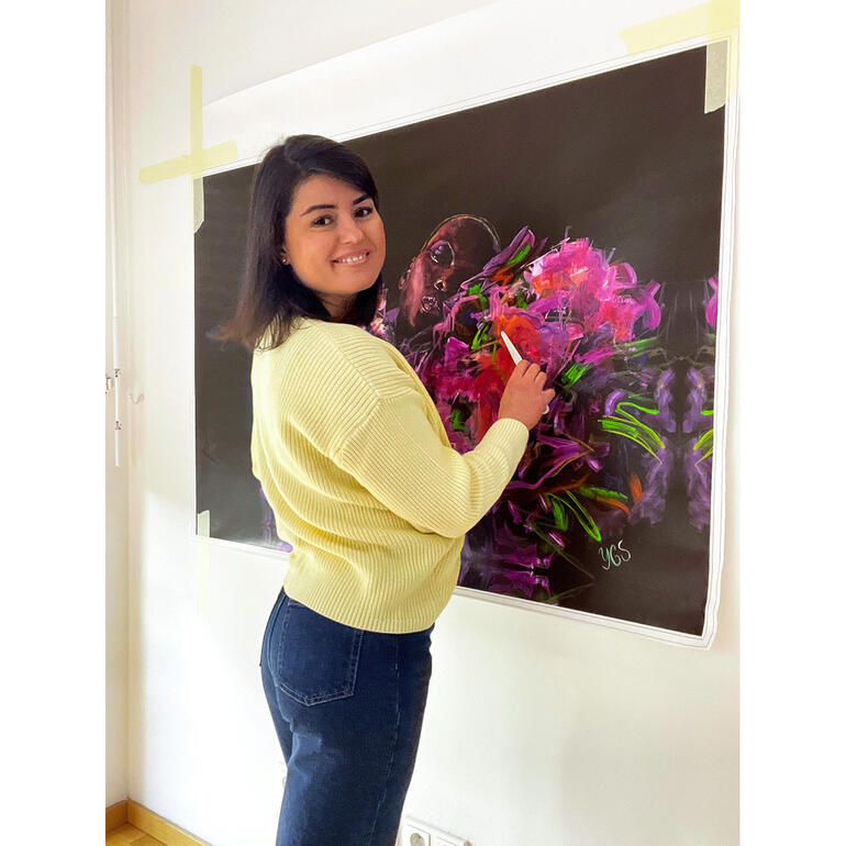 Yuliya Grzmehle Yuliya Grzmehle zeichnet mit einem Pinsel an einer großen Leinwand.